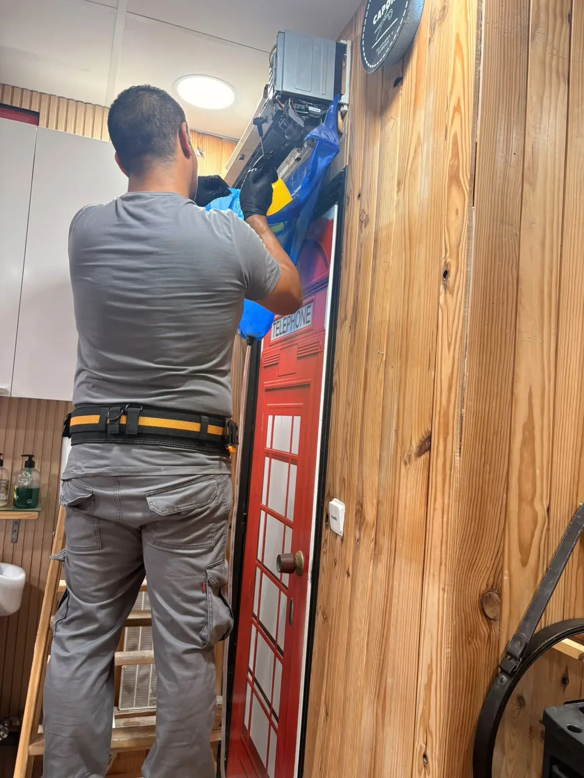 Técnico instalando aire acondicionado en un local comercial