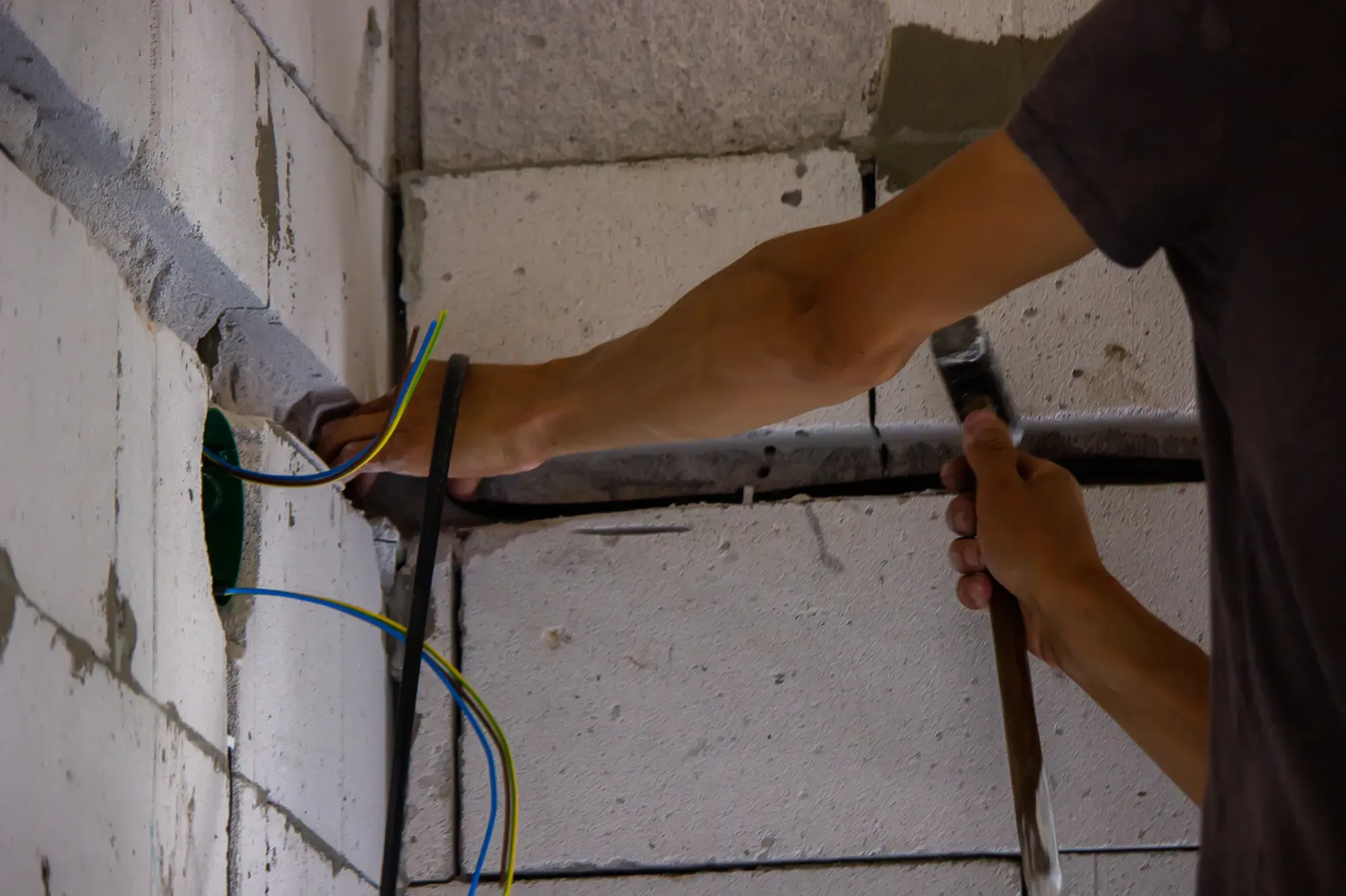 Electricista pasando cableado durante la reforma eléctrica de una vivienda