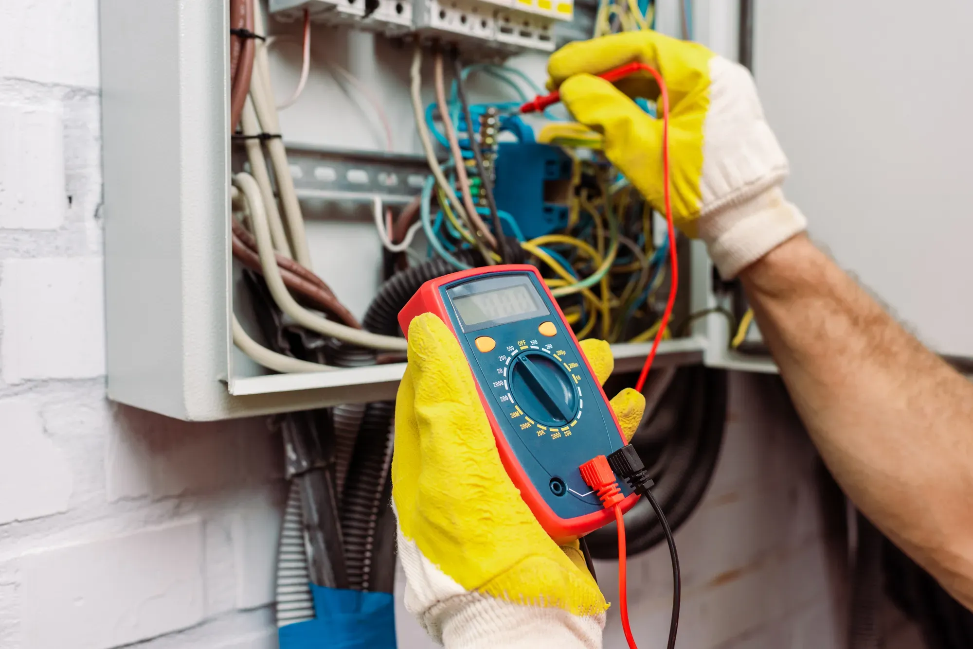 Electricista midiendo la tensión con un polímetro en un cuadro eléctrico
