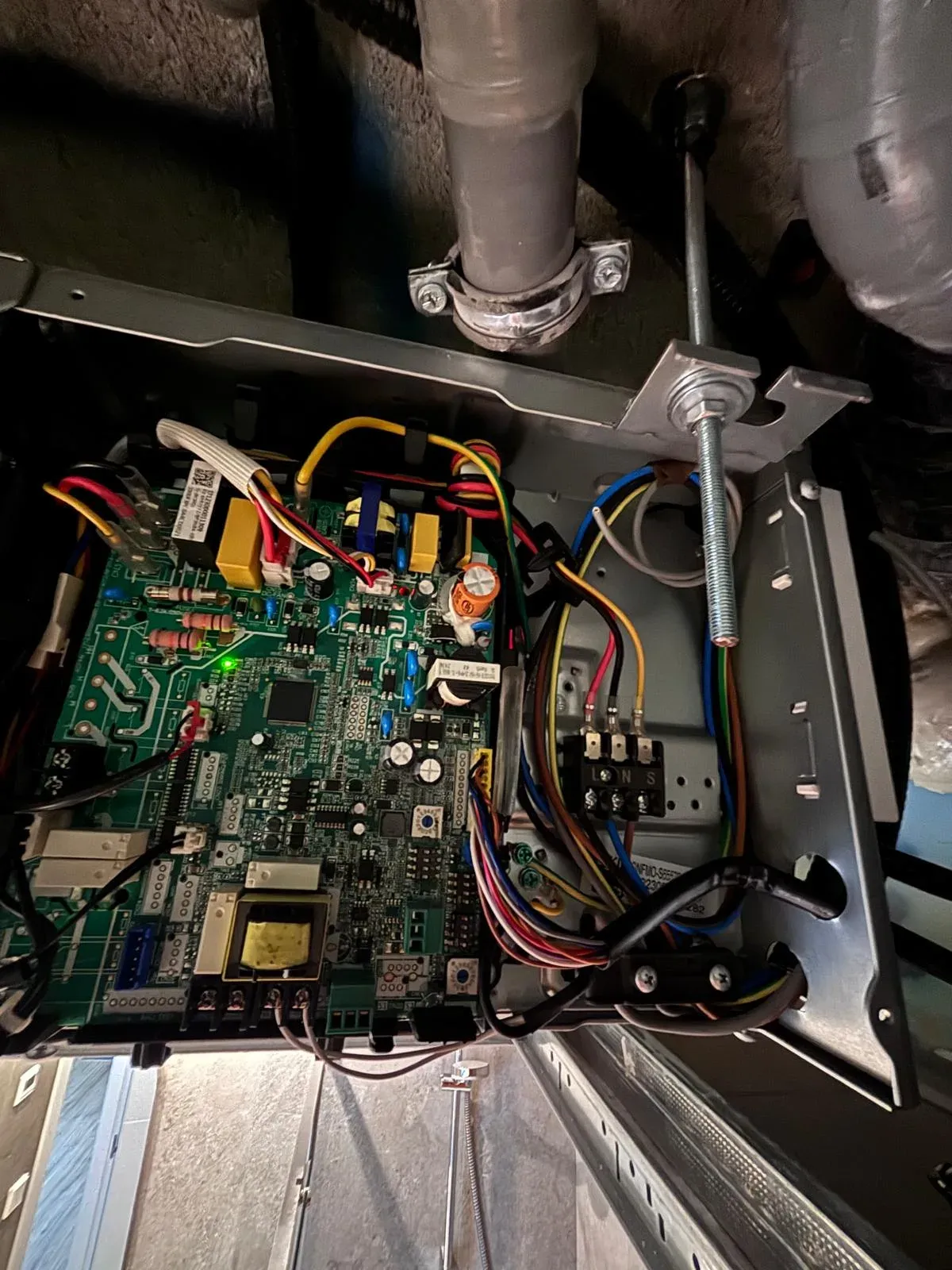 Placa electrónica de una máquina de aire acondicionado por conductos durante la reparación