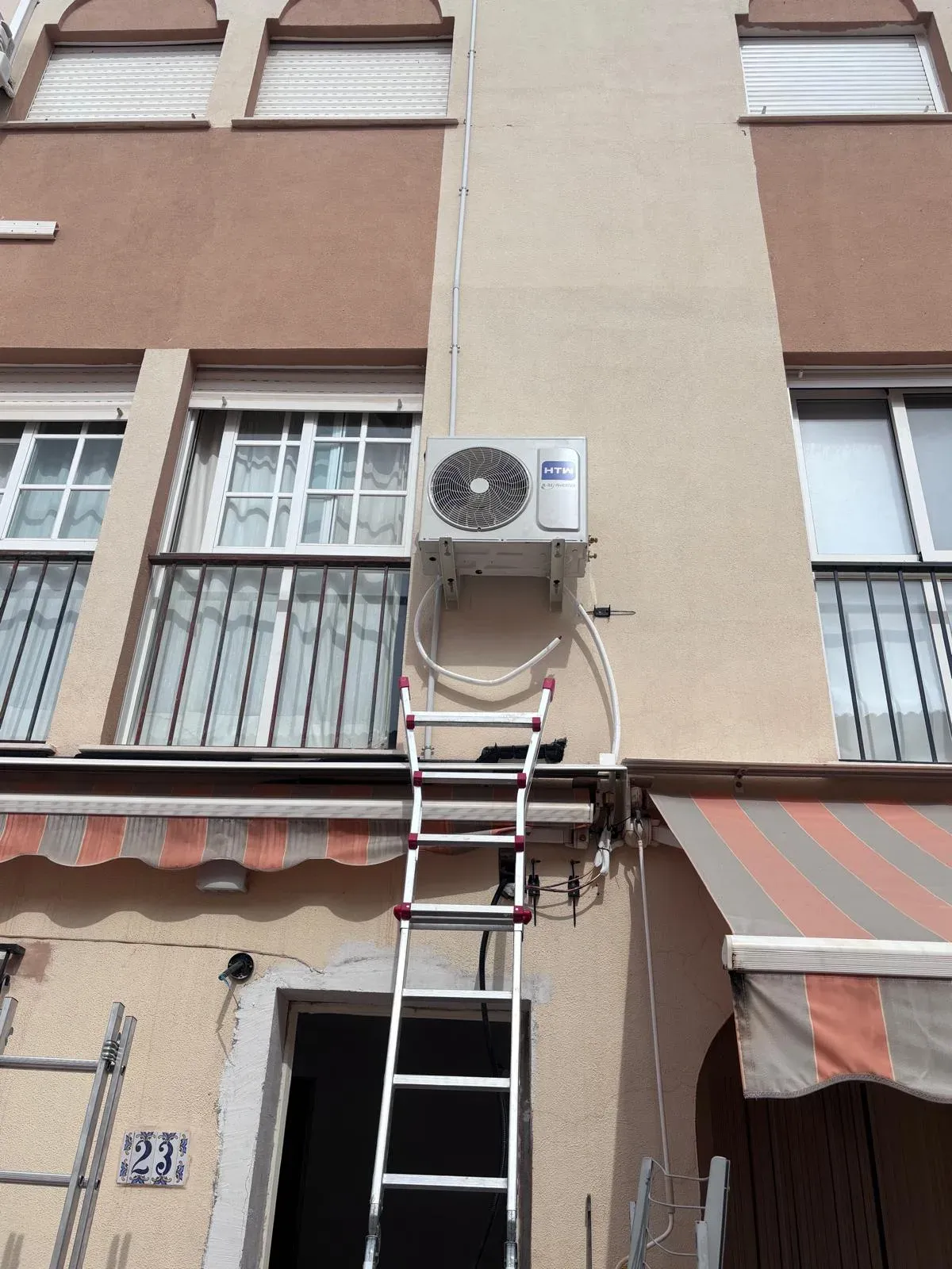 Unidad exterior de aire acondicionado instalada en la fachada de una vivienda